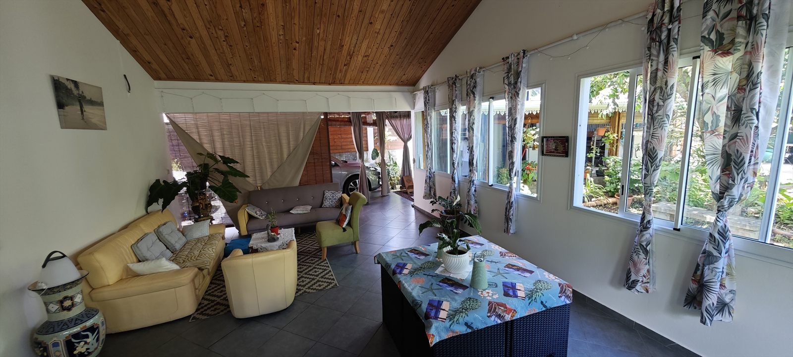 Salon-véranda spacieux avec rideaux à motifs tropicaux